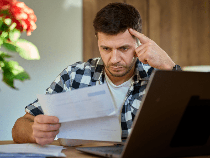 A stressed man reading a garnishee notice sent to him by the ATO