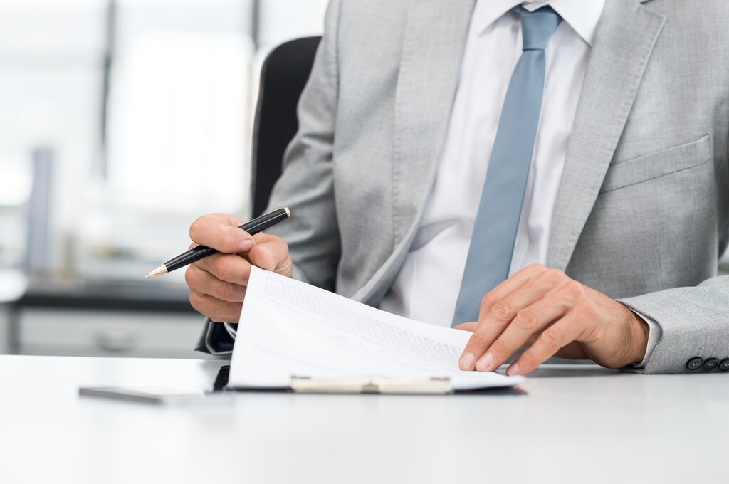 A man in a suit reading a document.