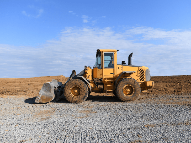 A small yellow bulldozer at a construction site