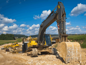 A large yellow excavator working on an ongoing construction or dig site