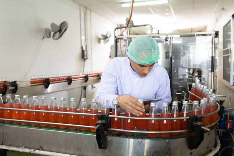male factory worker looking at basil seed drink