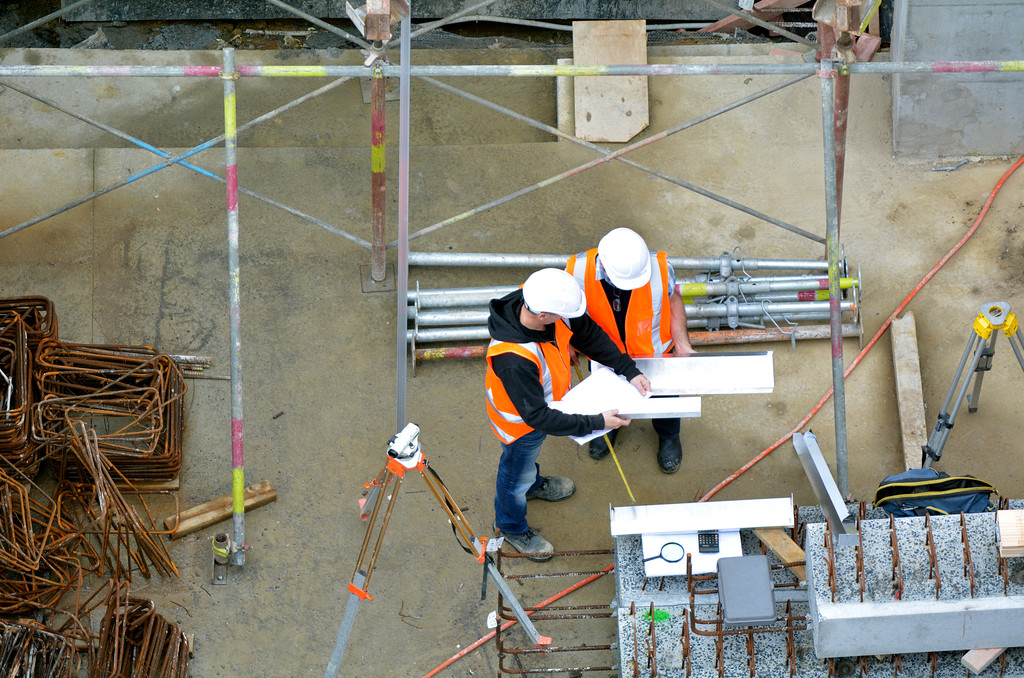 Aerial view of civil construction workers inspecting construction site.