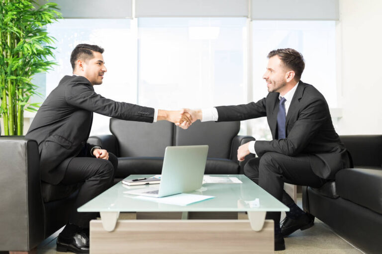 Two happy professional advisors shaking hands