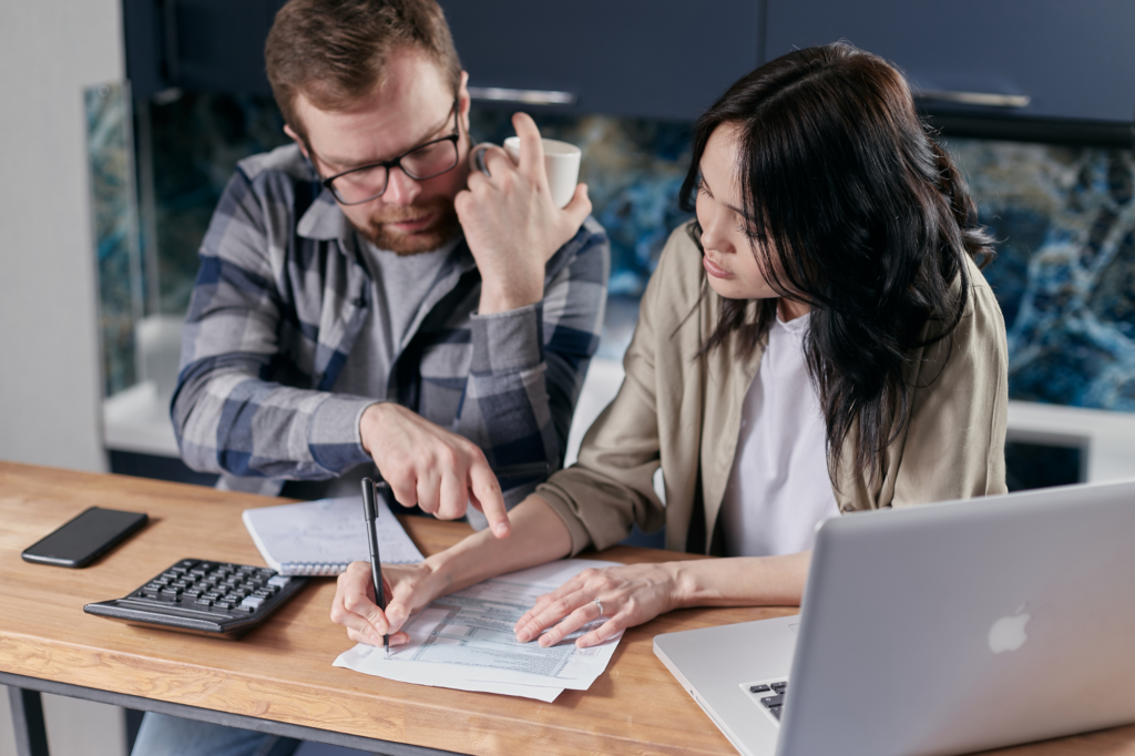 A man and a woman intently fill up forms, concept photo for business owners filling up a tax debt loan application