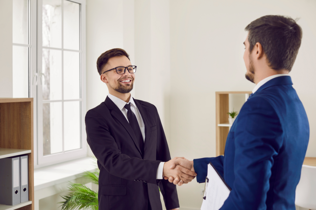 Two men in suits enthusiastically shake hands, concept photo for a business owner shaking hands with a lending expert or representative after getting approved for an unsecured business loan