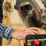 Carpenter work with circular saw for cutting boards