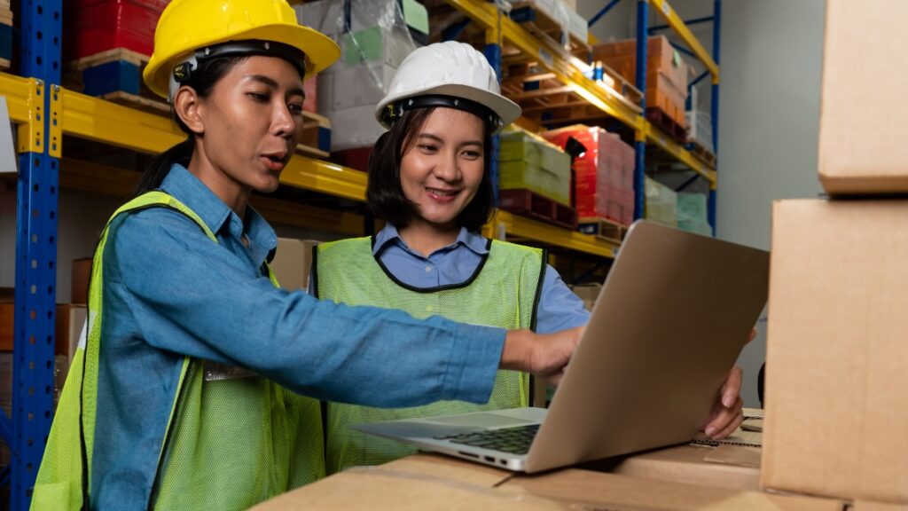 warehouse workers looking at laptop