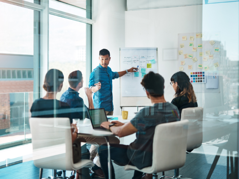 The core team of a small business is having a meeting in a conference room about business expansion strategies