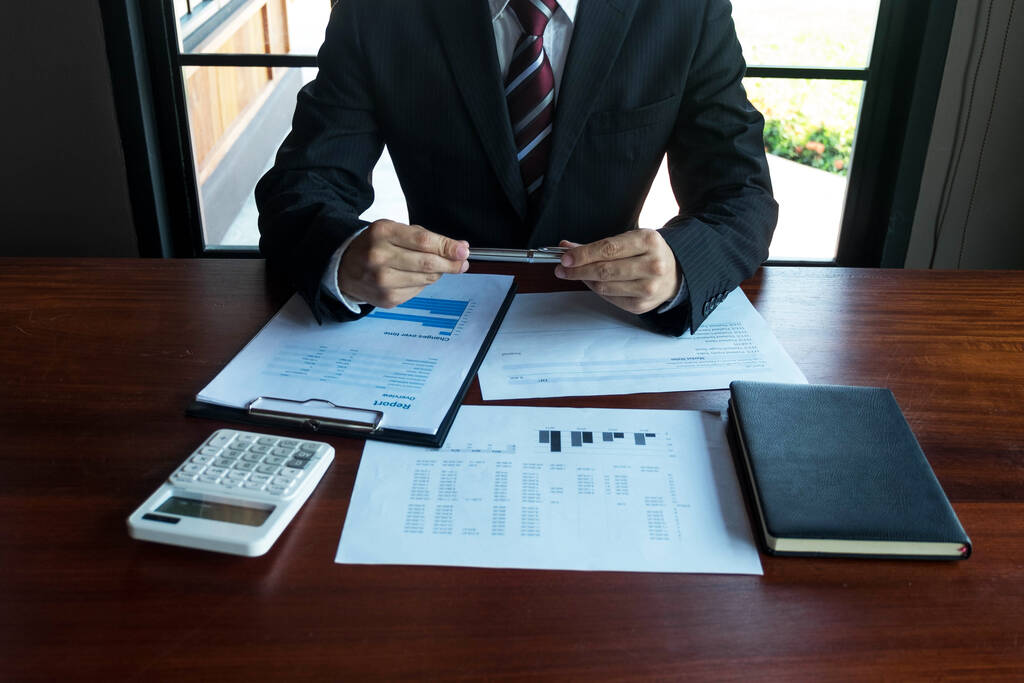 Businessman working with income statement document