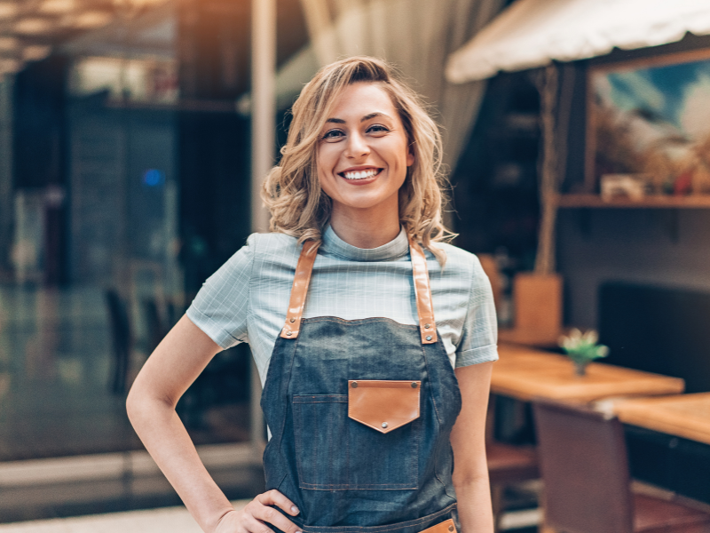 A female business owner posing in front of her business