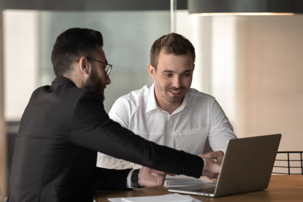 Lender or broker presenting a client with a loan, pointing at laptop screen