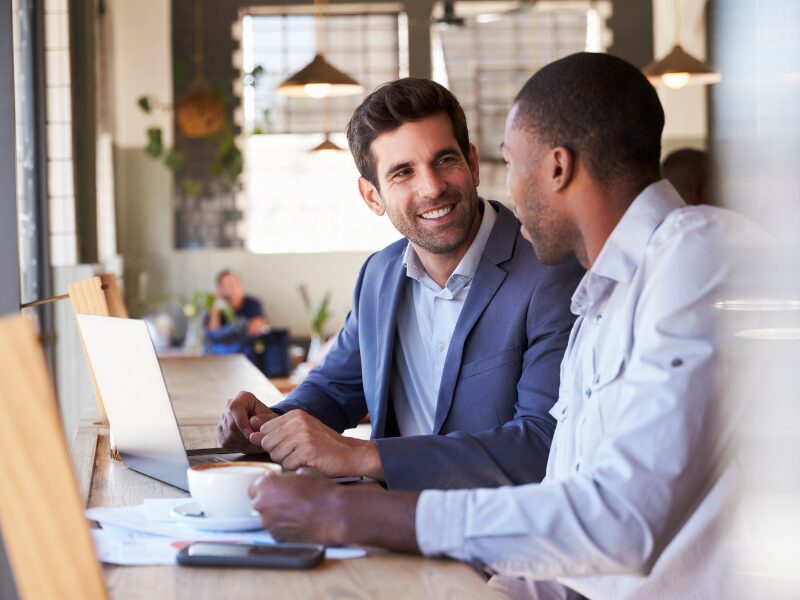 Two business owners in a lively discussion over a cup of coffee