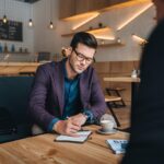 Man discussing cafe finance for his business with partner