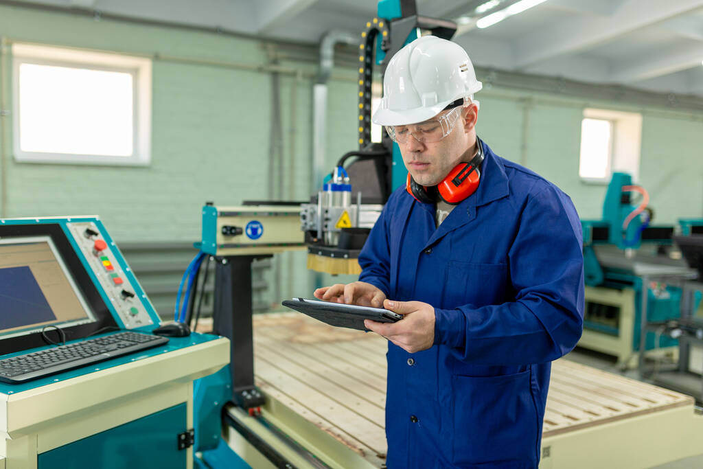 Worker looking at tablet in manufacturing small business