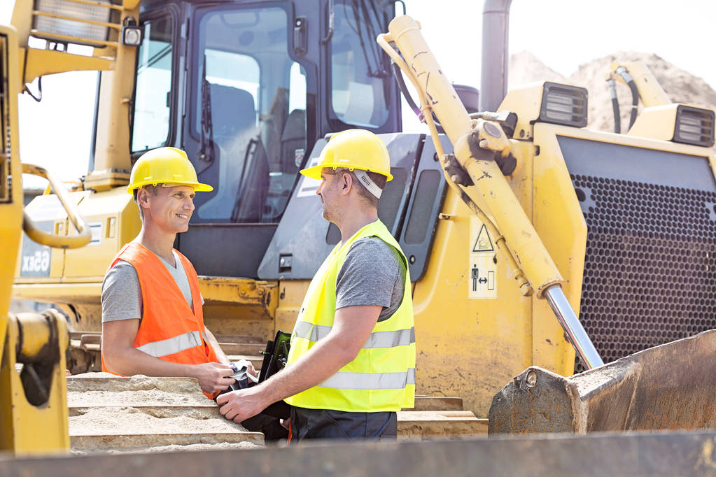 Two construction workers discussing business growth strategies
