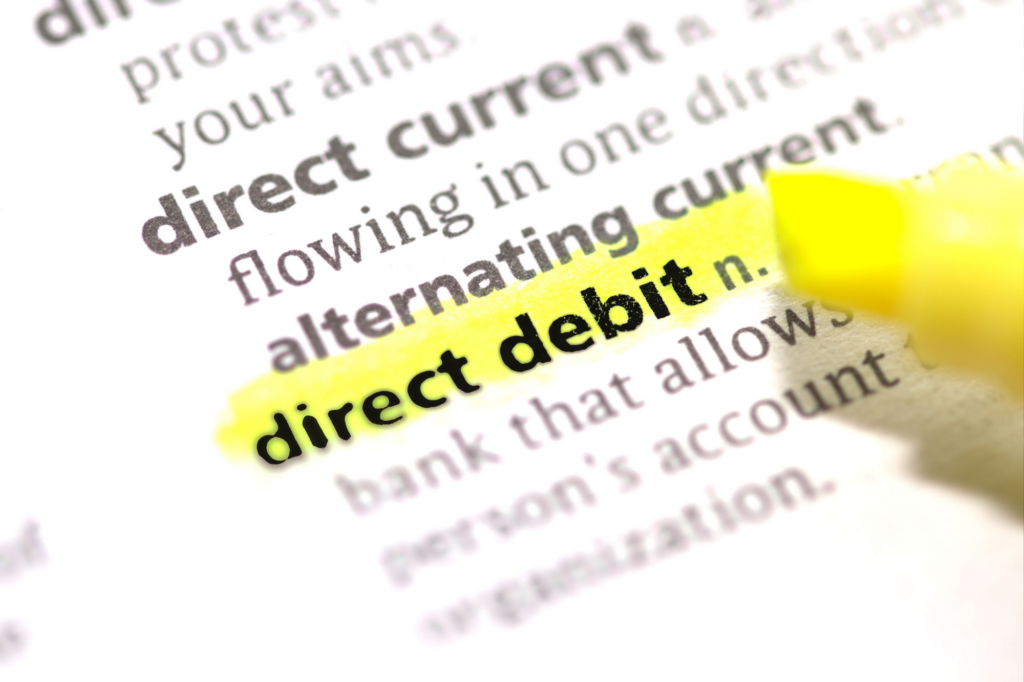 Zoom in shot of a dictionary or glossary with the term "direct debit" highlighted in yellow