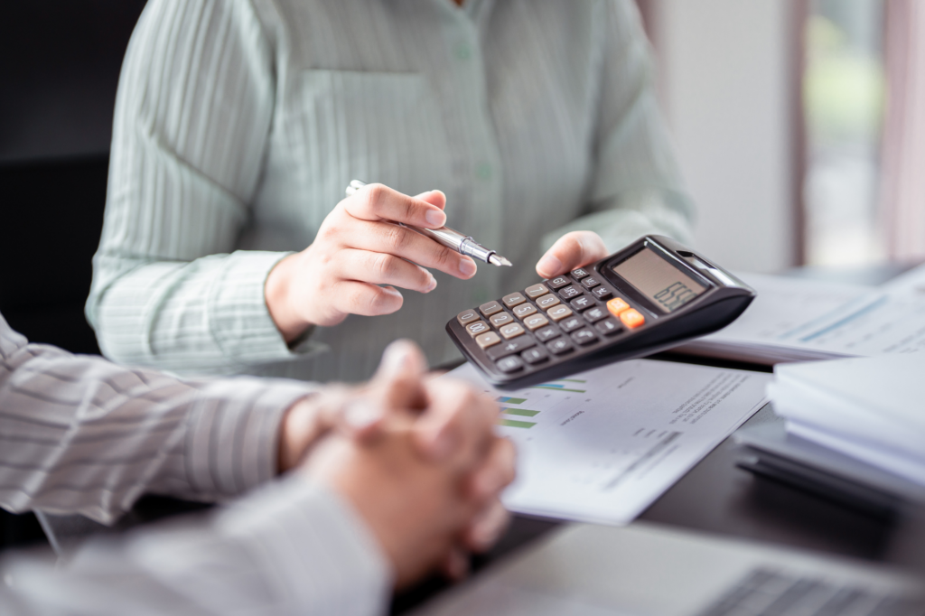 Loan broker showing calculator to client, showing home loan rates, cropped photo