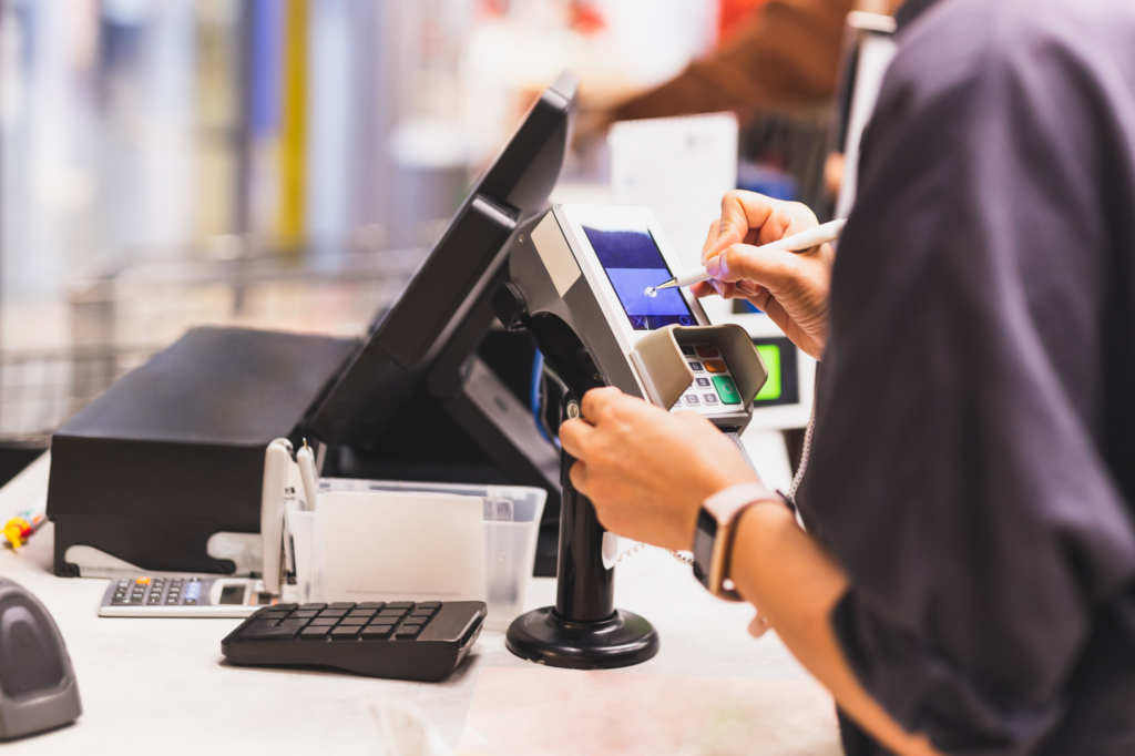 Cropped image of buyer paying using the POS at the cashier