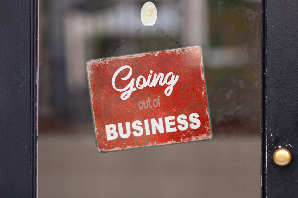 weathered door signage in red with mixed fonts saying "going out of business:"