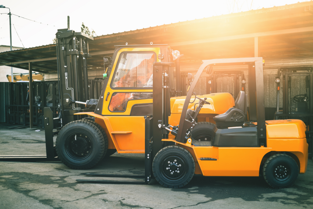 Side view atmospheric photo of 2 yellow forklifts, soft sunlight shining, concept photo for asset based loans, using equipment as security for loans