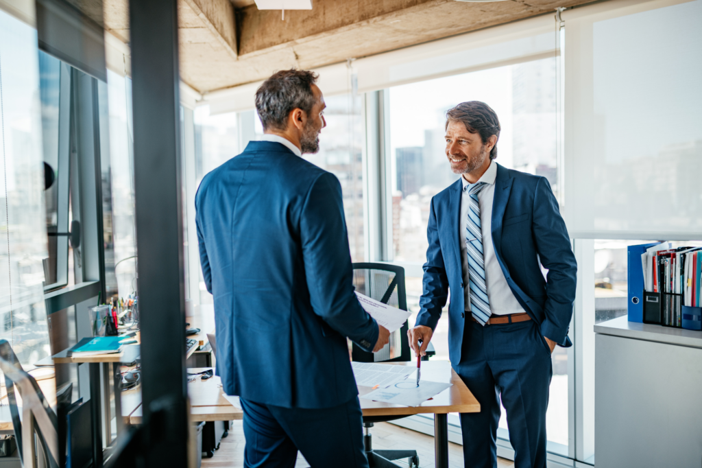 Two men in suits standing and having a spirited conversation, concept photo for business owner and investor discussing funding, equity financing