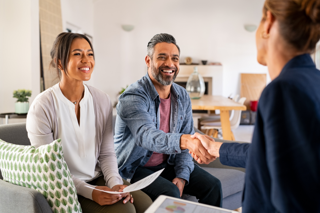 Happy couple shakes hand with loan broker, lender, lending expert, happy, caveat loan approval for business owners