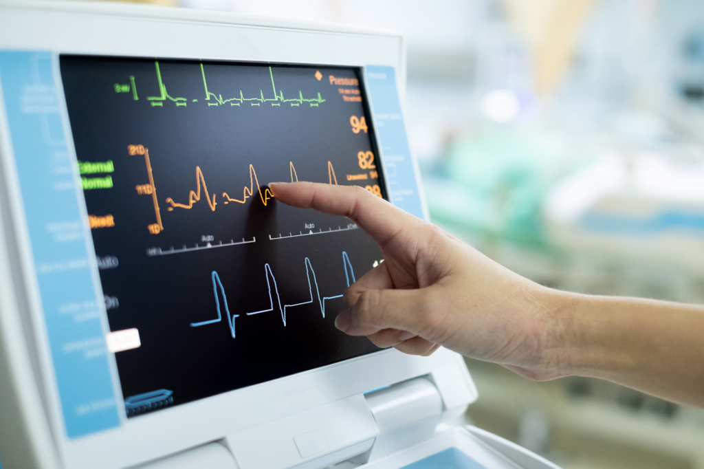 Close-up photo of a medical professional pressing the screen of a vital signs monitor, photo of medical equipment