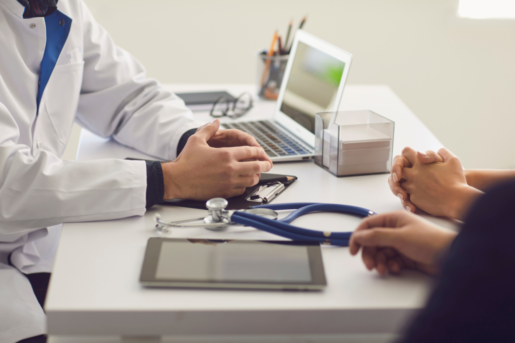 Cropped photo of a doctor and patients’ hands resting on a doctor’s table, discussing results, clinic appointment, doctor setting up own practice after getting medical practice loans