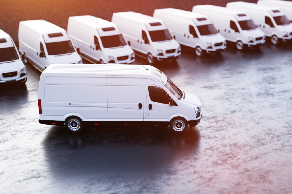 Atmospheric photo of a fleet of vans with one van driving away