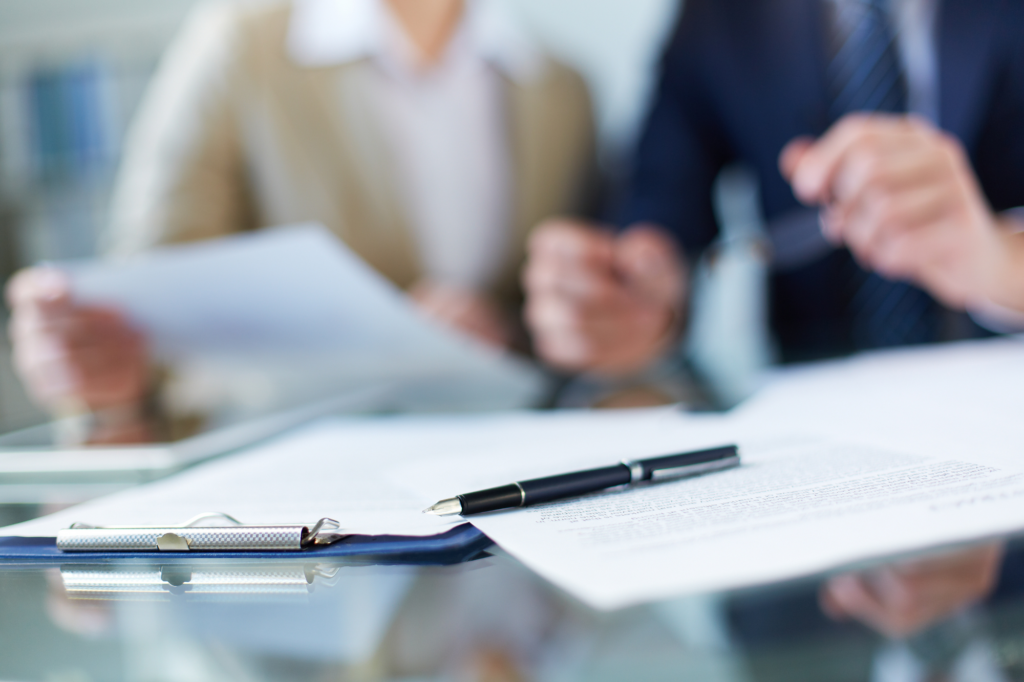 Unfocused and cropped photo of a man and woman discussing a document, concept photo for reviewing terms of cash flow lending or cash flow loan