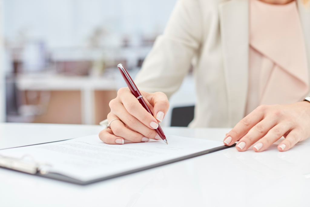 Cropped photo of a woman signing papers, concept photo for signing loan agreement for an unsecured business overdraft