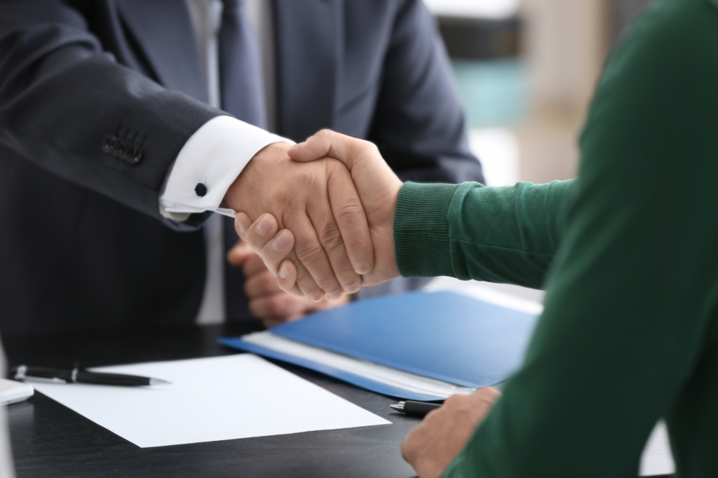 Cropped photo of two people shaking hands over a table, concept photo of a business owner agreeing to private loan terms