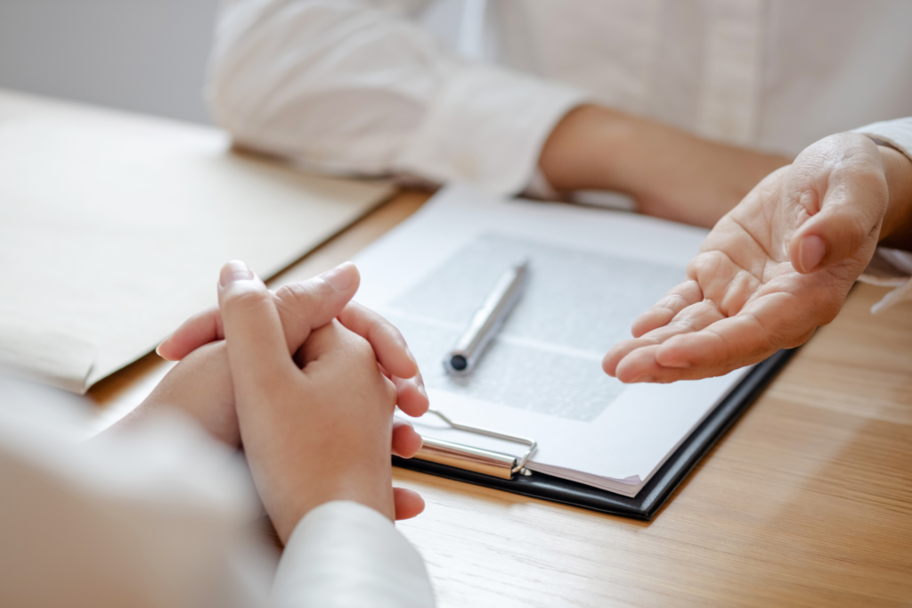 Cropped photo showing the hands of two people discussing a document or contract, concept photo for a lender or broker discussing low doc business loan requirements with a borrower