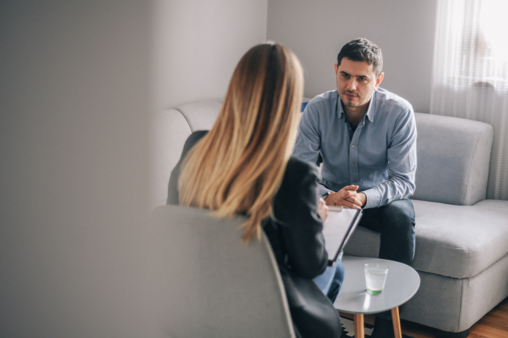 A man has a focused expression as he meets with a woman holding documents, meeting with lender or broker for SMSF loan