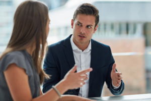 A man and a woman in a professional setting having a serious discussion, talking about SMSF loans and common misconceptions