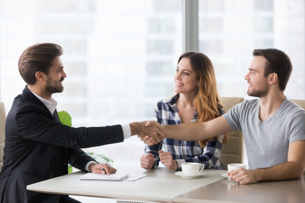 A couple meet and shake hands with a lender or broker for a tax debt loan, concept photo for choosing tax debt loan instead of a payment plan ATO