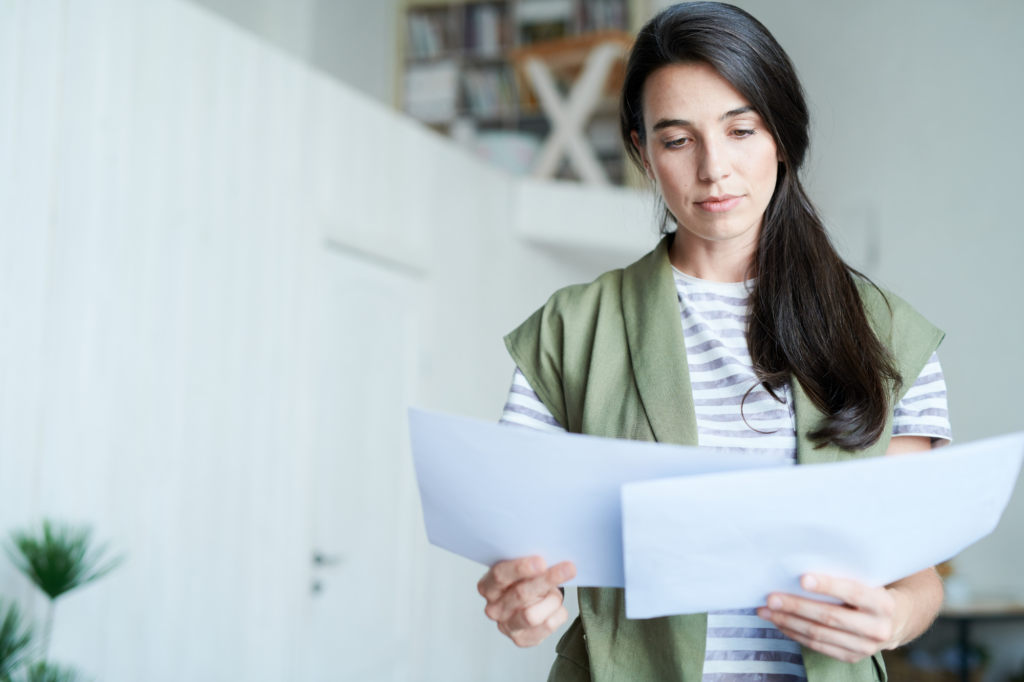 A woman reviewing two documents and comparing, concept photo for comparing ATO payment plans and tax debt loans to make a choice