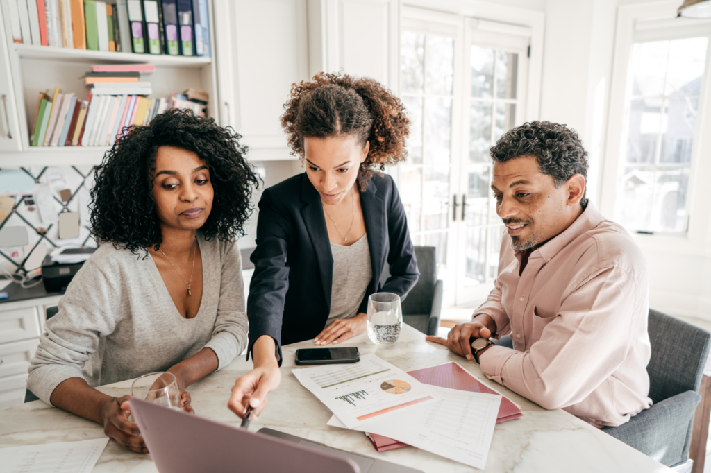 A lender or broker discusses the details of a private loan to two business owners interested in financing