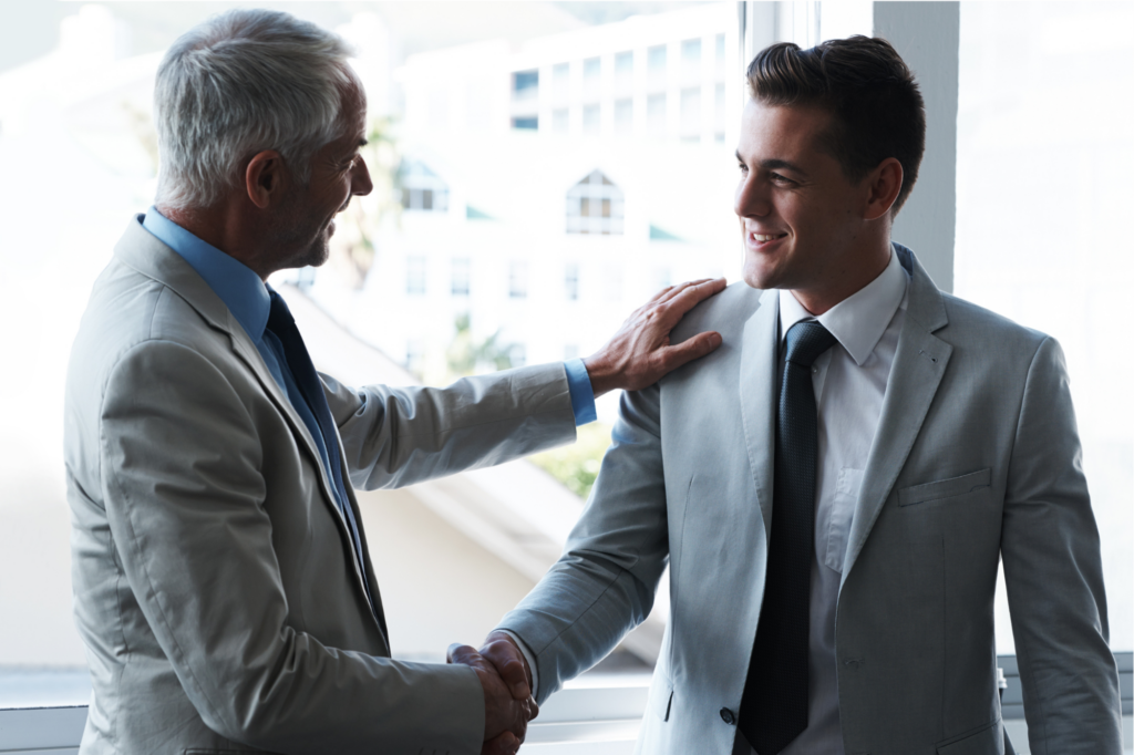 Two businessmen shaking hands, two business owners in good relationship or standing with each other because of good reputation