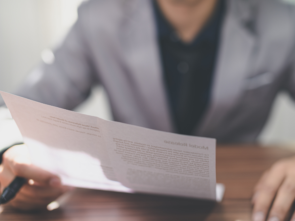 Cropped photo of a man reading a document, concept photo of a buyer reading a notice to complete from a seller