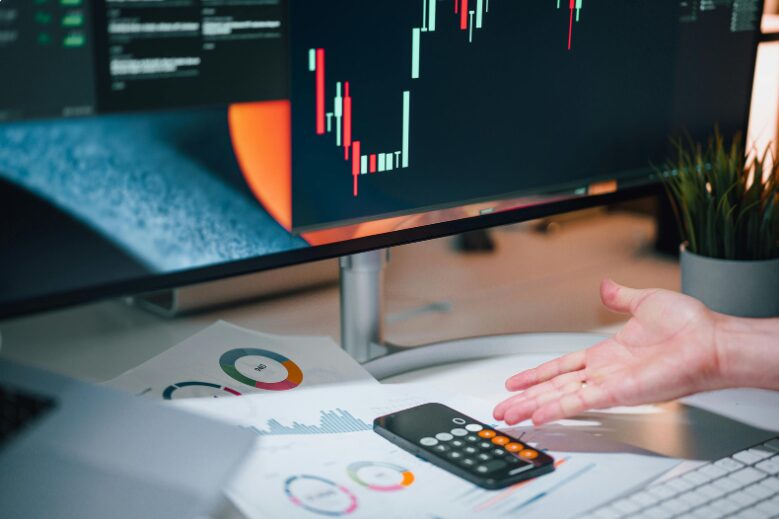 Image of a calculator placed beside red and green trade lines, representing the role of a trade finance facility in managing trade transactions.