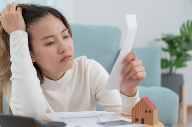 A stressed small business owner reviewing hidden fees and penalties from a private lender 2nd mortgage during the pandemic, highlighting the importance of choosing the right second mortgage.