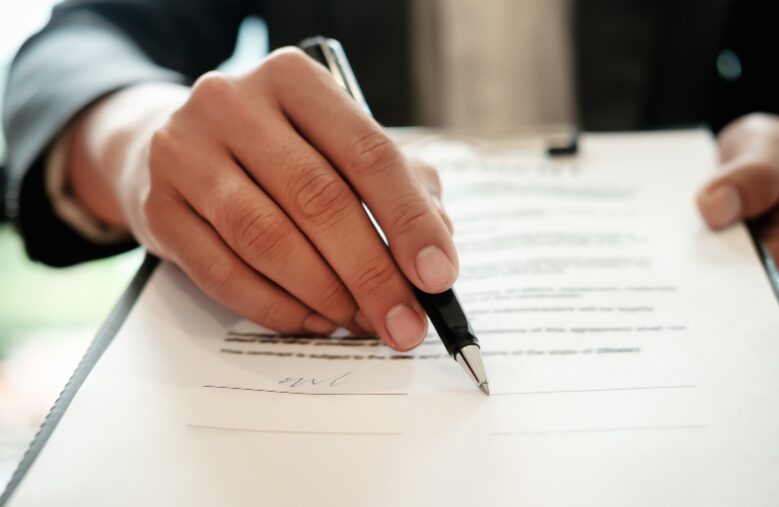 A business professional reviewing a document and pointing to the signature section, symbolising the streamlined process of securing fast business loans in Australia.