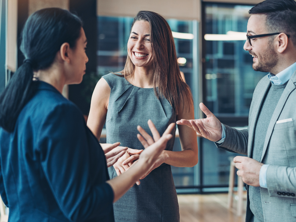 Three people in a professional setting have a cheery and animated discussion, business owners discussing an unsecured loan in Sydney with a broker or lender