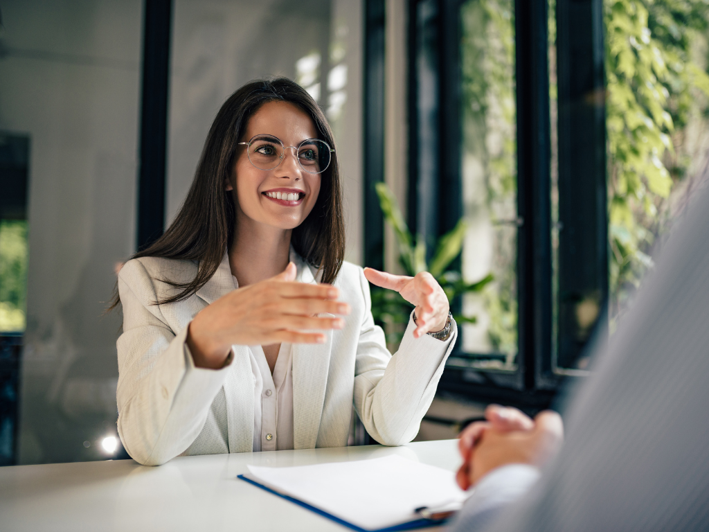 A woman in a professional setting sits across a man off camera, happy discussion, discussing unsecured business loans in Sydney