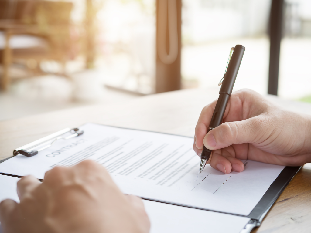 Cropped photo of a hand signing a loan contract, agreeing to terms for an unsecured business loan in Sydney