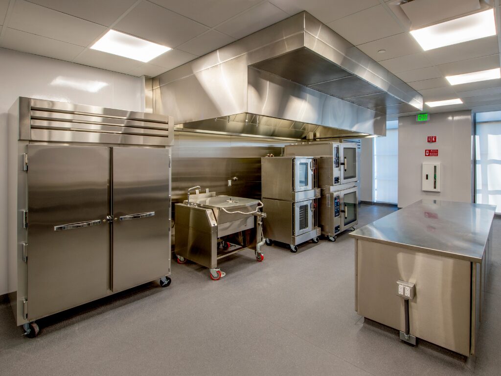 Brand new and shiny stainless steel industrial kitchen equipment, ovens, refrigerators, countertops, and more, industrial kitchen outfitted with fitout finance