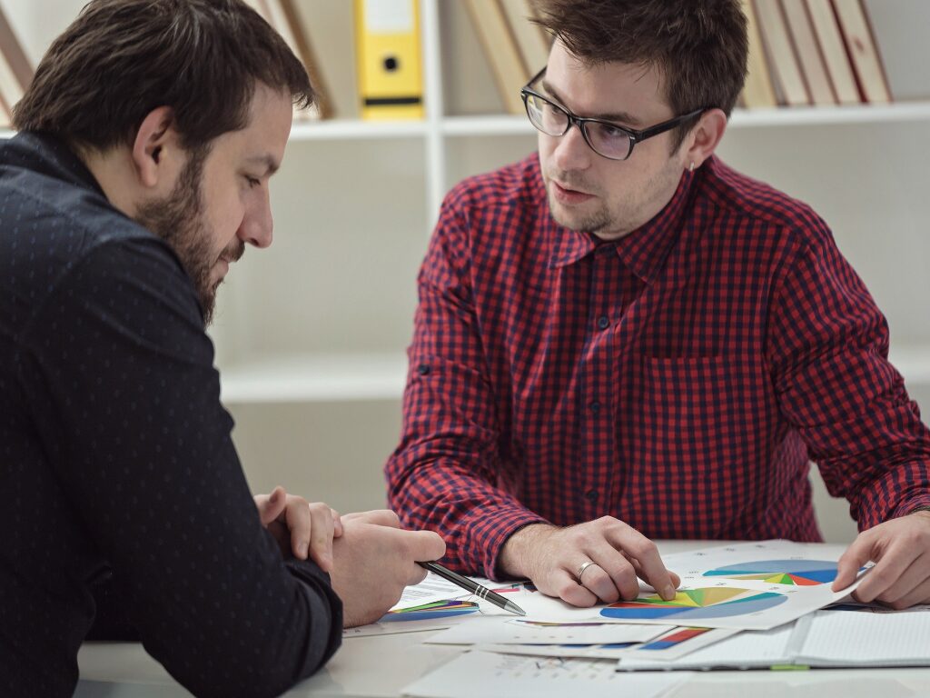 Two business owners review their financials and income to determine what business loan they are qualified for