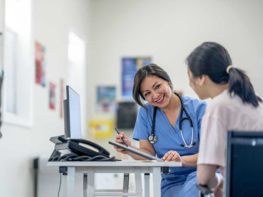 An allied health professional happily talks to a patient