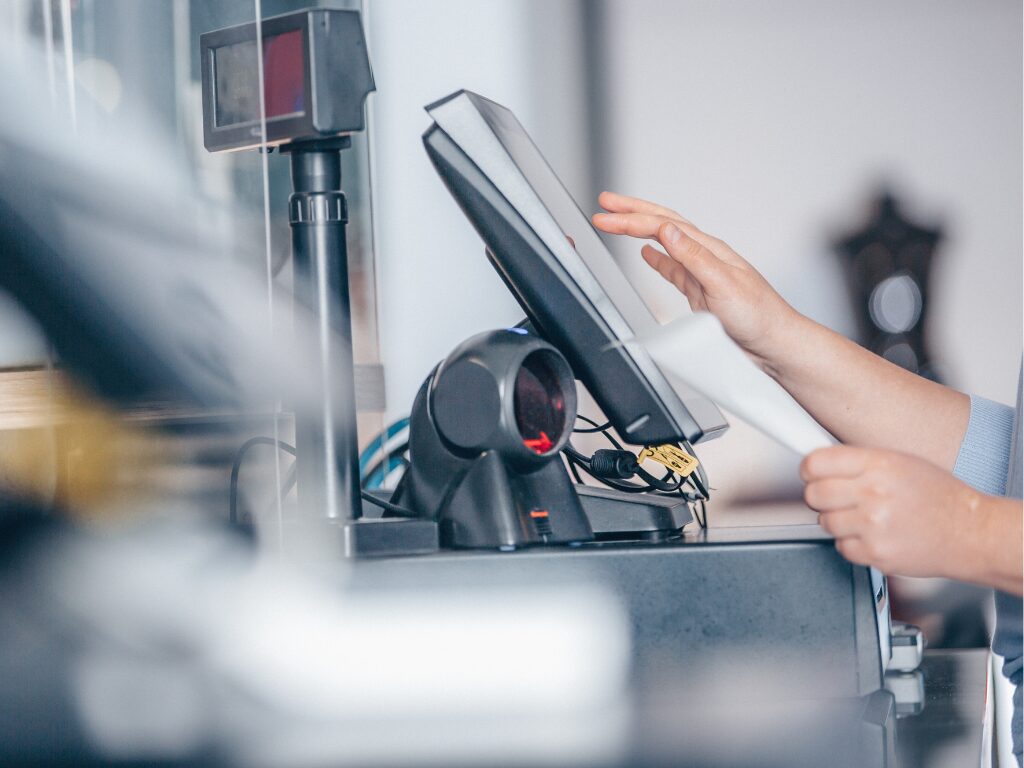 Cropped photo of a cashier using a point of sale machine